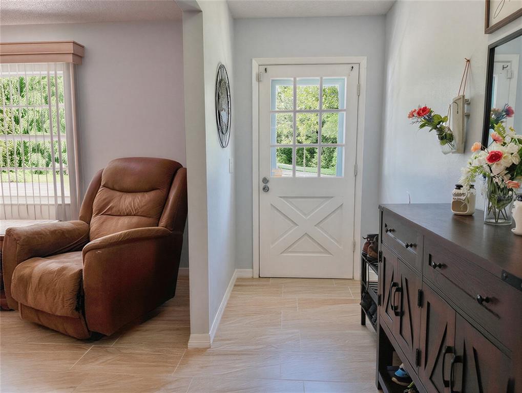 An entryway features a blue front door, a wooden console table, and a shoe rack — 3931 GAILLARDIA DRIVE, INDIAN LAKE ESTATES, FL