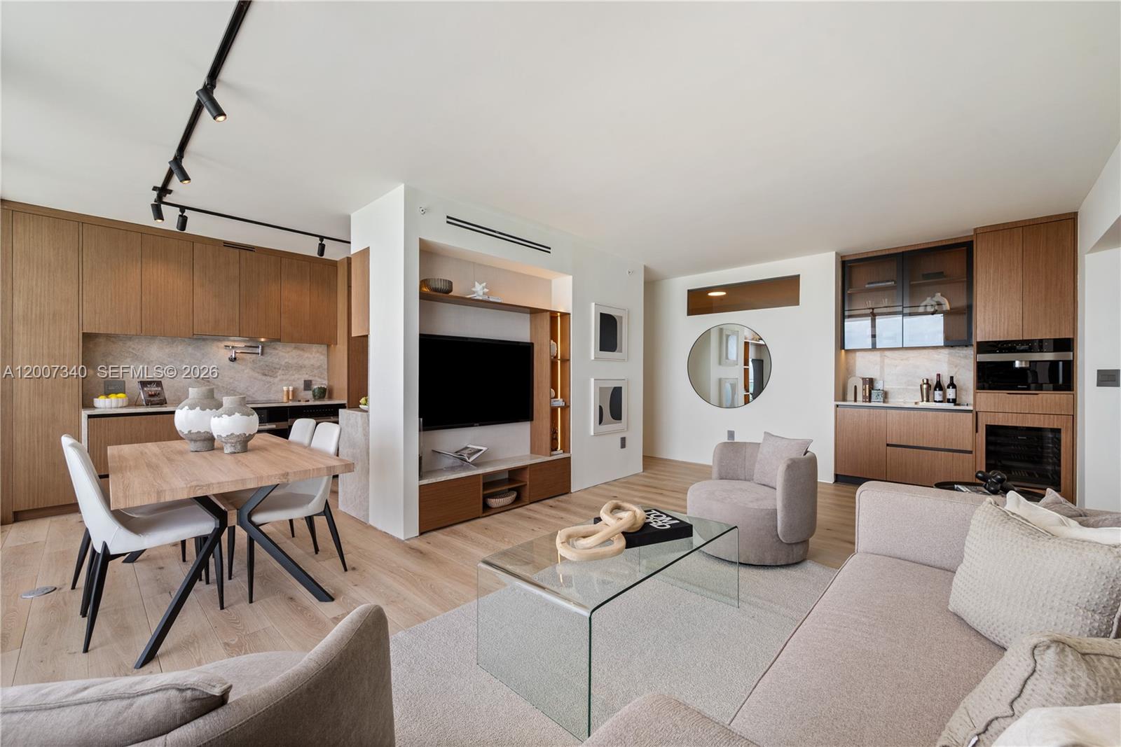 This open-concept living area features a kitchen, dining space, and lounge with wood cabinetry — 6365 Collins Ave # 3904, Miami Beach FL 33141, MIAMI BEACH, FL