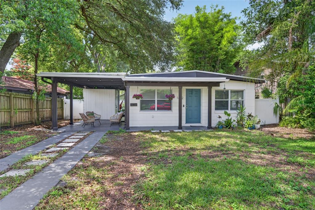 A single-story white house with a carport, a blue front door, and a grassy yard — 1822 CANTON STREET, ORLANDO, FL