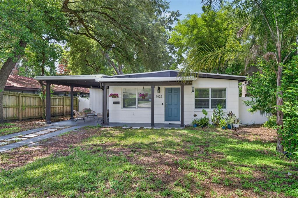 A single-story white house with a blue front door and a covered carport — 1822 CANTON STREET, ORLANDO, FL