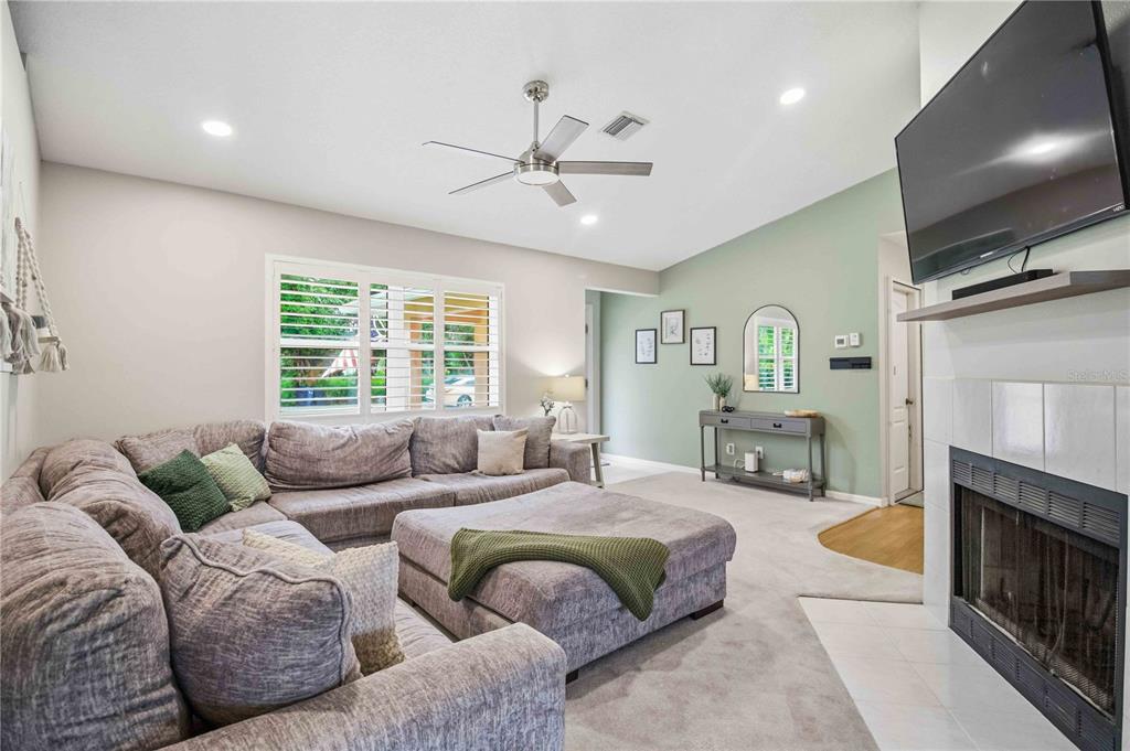 A living room features a large gray sectional sofa, a fireplace, and a green accent wall — 3131 ARROWHEAD ROAD, VENICE, FL