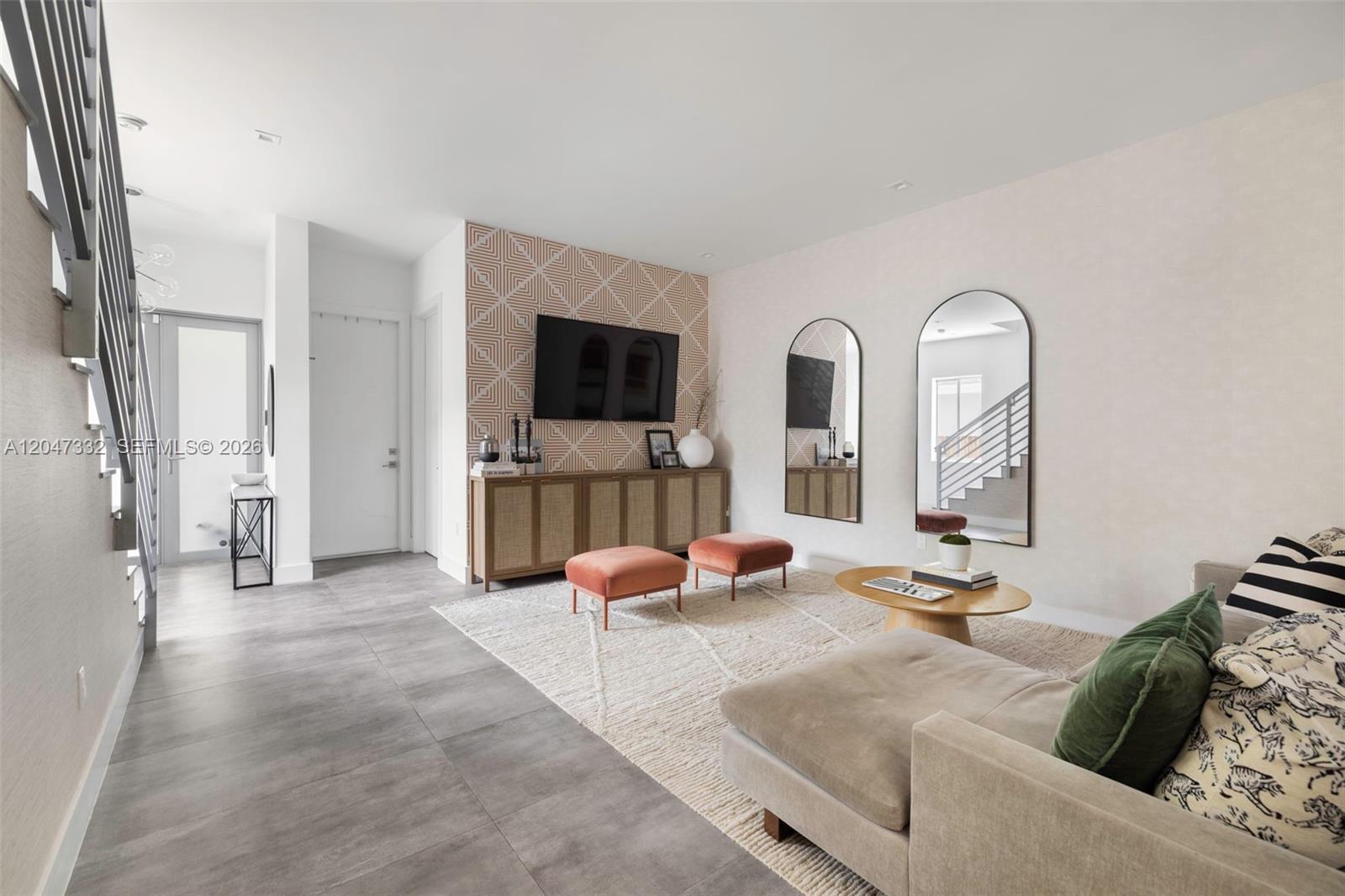 A living room features a patterned accent wall, a television, two arched mirrors, and furniture — 3139 Ohio St # 3139, Coconut Grove FL 33133, COCONUT GROVE, FL