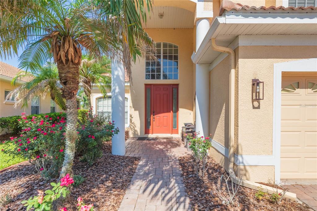 A two-story suburban house with a tan stucco exterior, tile roof, and a paved driveway — 18018 JAVA ISLE DRIVE, TAMPA, FL