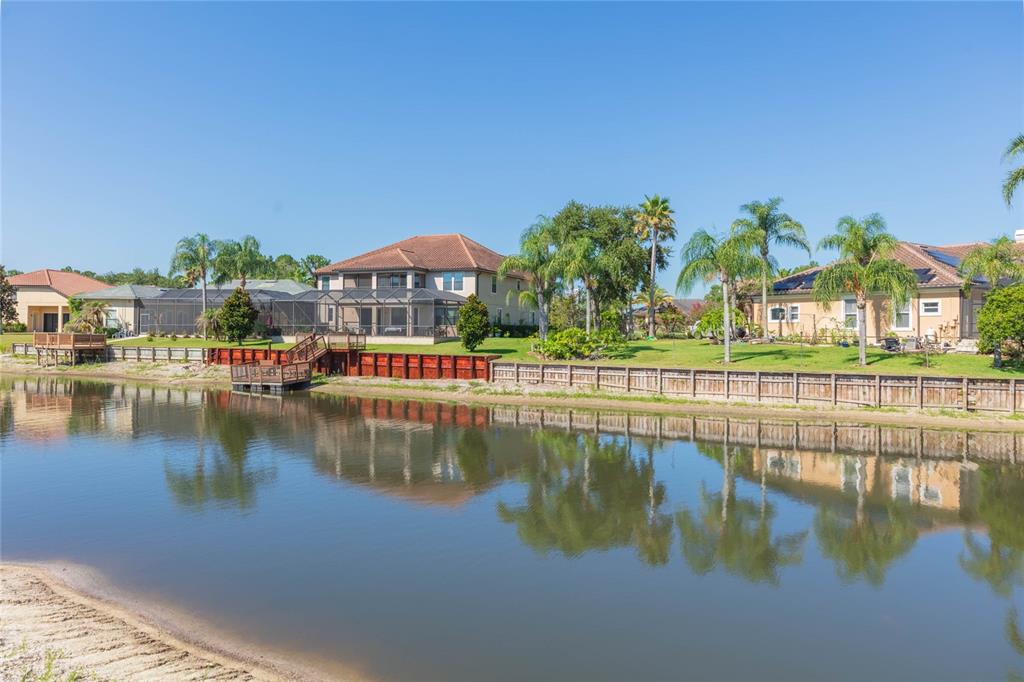 The exterior of a house features a red front door, white columns, and a walkway — 18018 JAVA ISLE DRIVE, TAMPA, FL