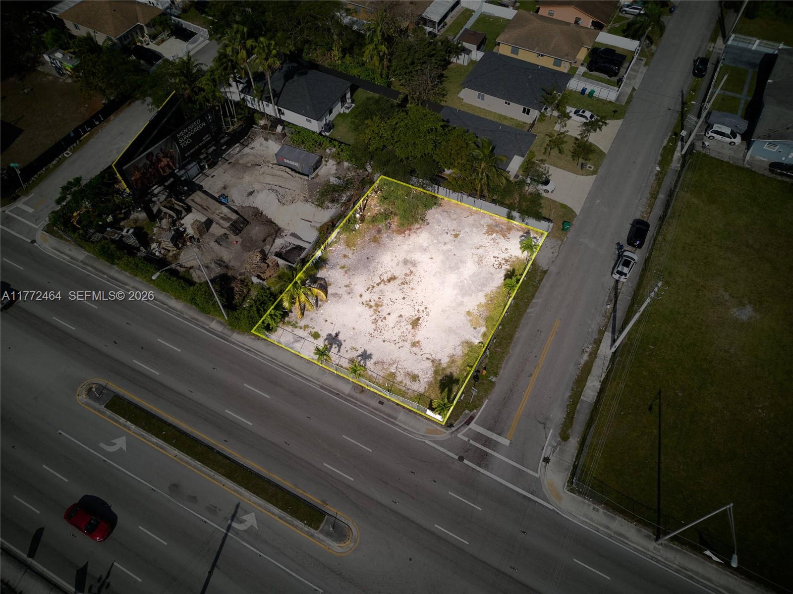 An aerial view shows a vacant, fenced-in rectangular lot situated at a street corner — 1405 NW 79th St, Miami FL 33147, MIAMI, FL