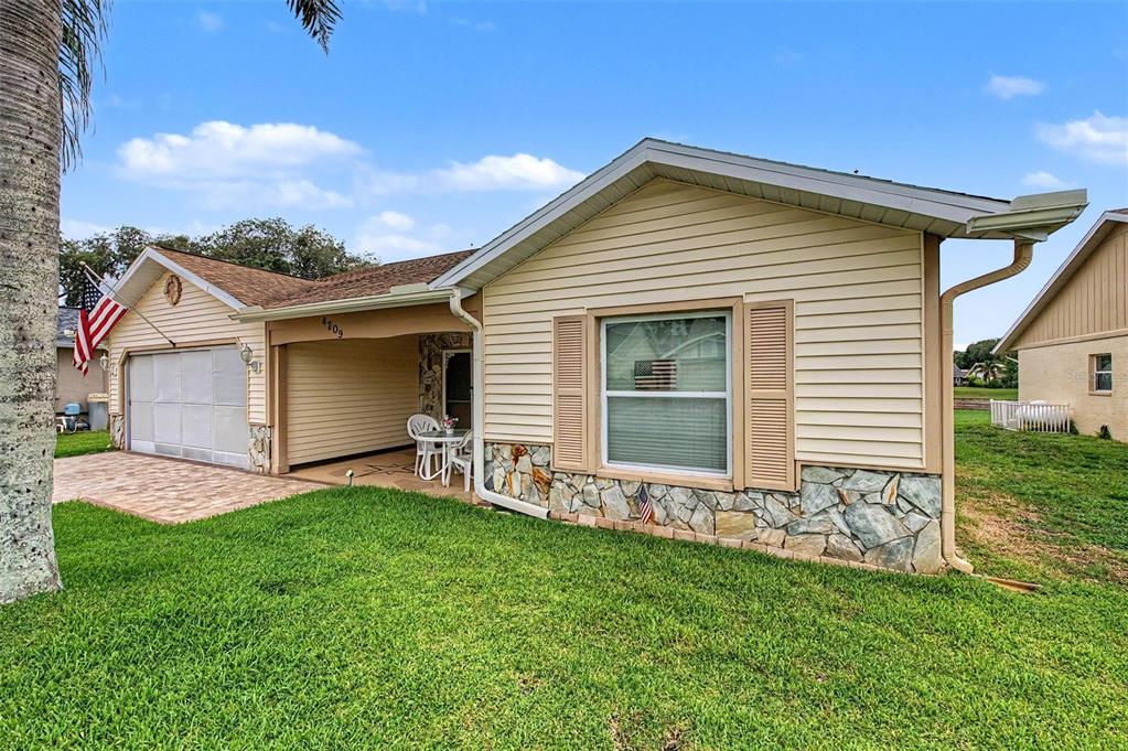 A single-story house with beige siding, a stone facade, and a covered front porch — 4709 PORTLAND MANOR DRIVE, NEW PORT RICHEY, FL