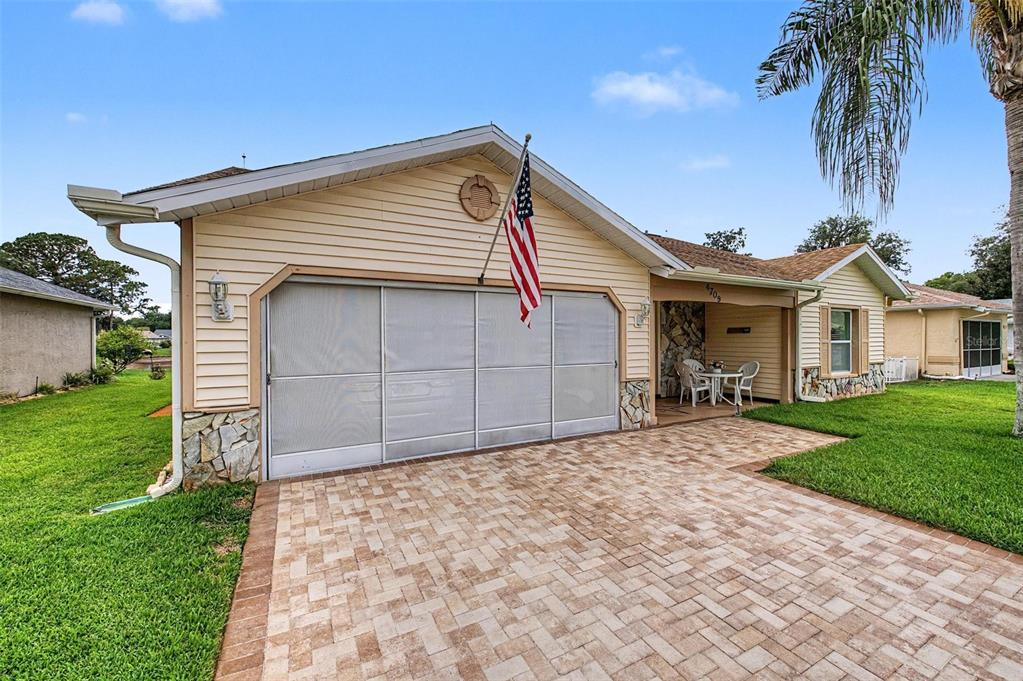 A single-story house with light siding, a stone facade, and a paved driveway — 4709 PORTLAND MANOR DRIVE, NEW PORT RICHEY, FL