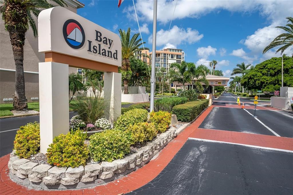 A sign for Bay Island stands at the entrance to a gated residential community — 7600 SUN ISLAND DRIVE S UNIT 204, SOUTH PASADENA, FL
