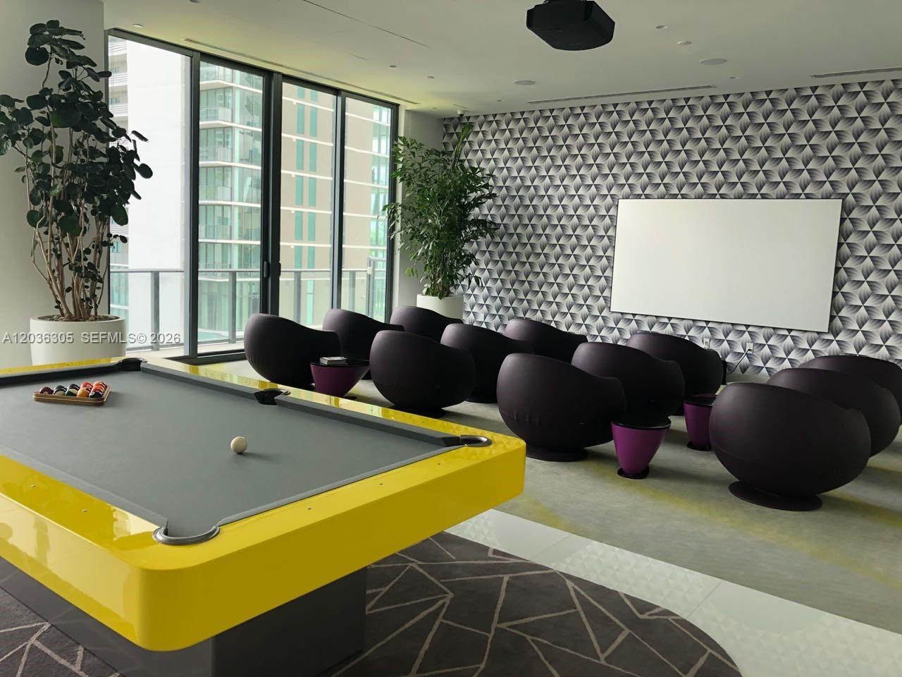 A game room features a yellow pool table, purple chairs, and a patterned accent wall — MIAMI, FL