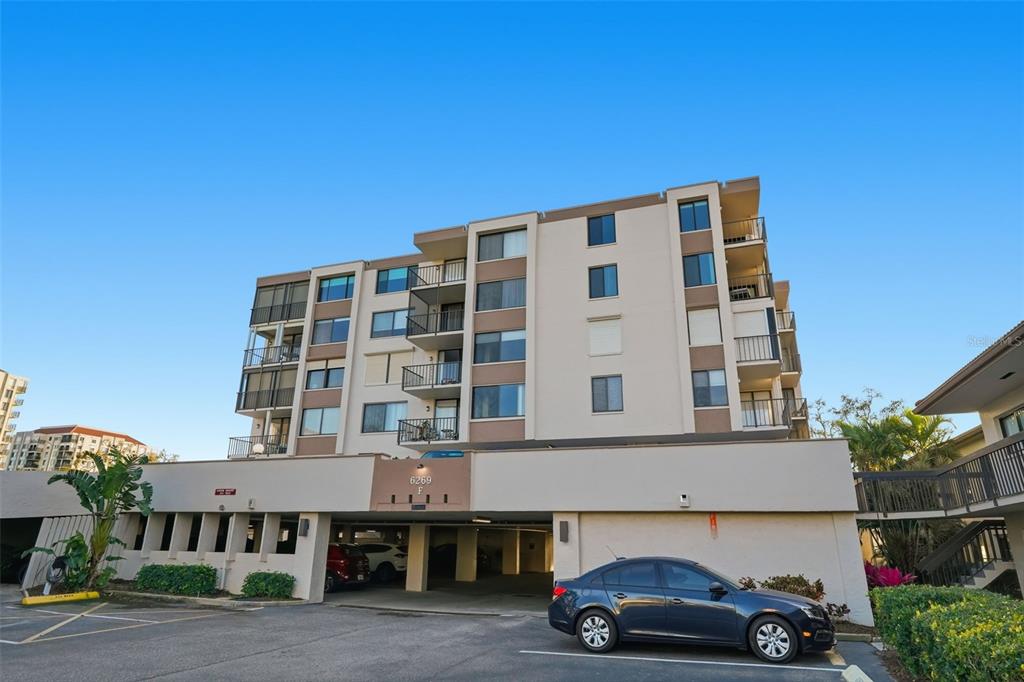 A multi-story apartment building with a ground-level parking garage and balconies — 6269 PALMA DEL MAR BOULEVARD S UNIT 608, ST PETERSBURG, FL