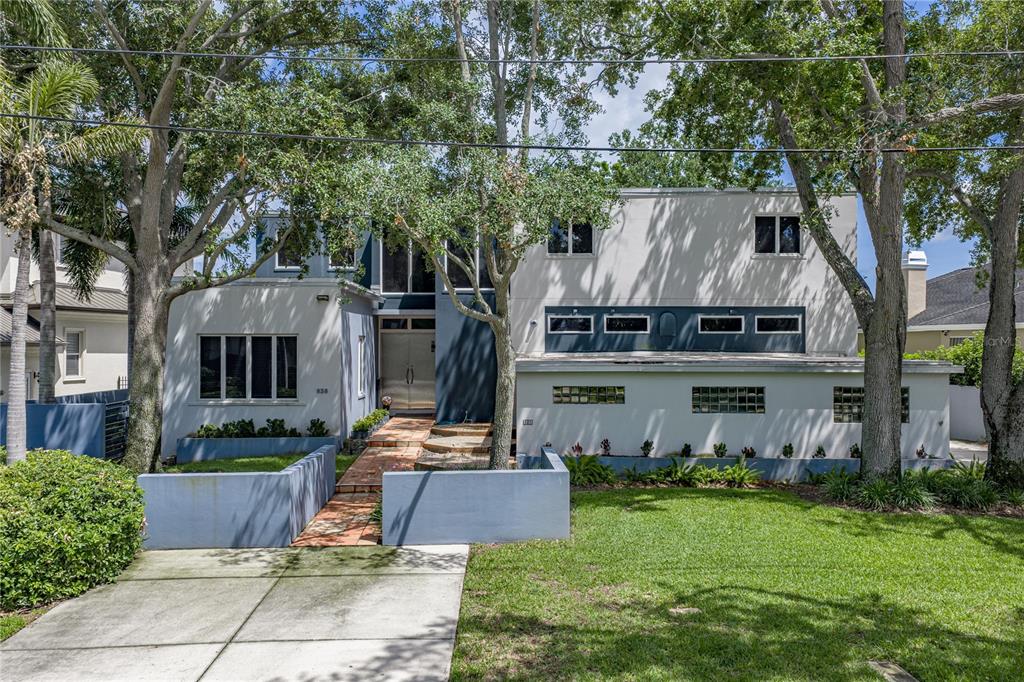 A two-story modern house with a flat roof, light-colored stucco, and glass block windows — 838 MONTEREY BOULEVARD NE, ST PETERSBURG, FL