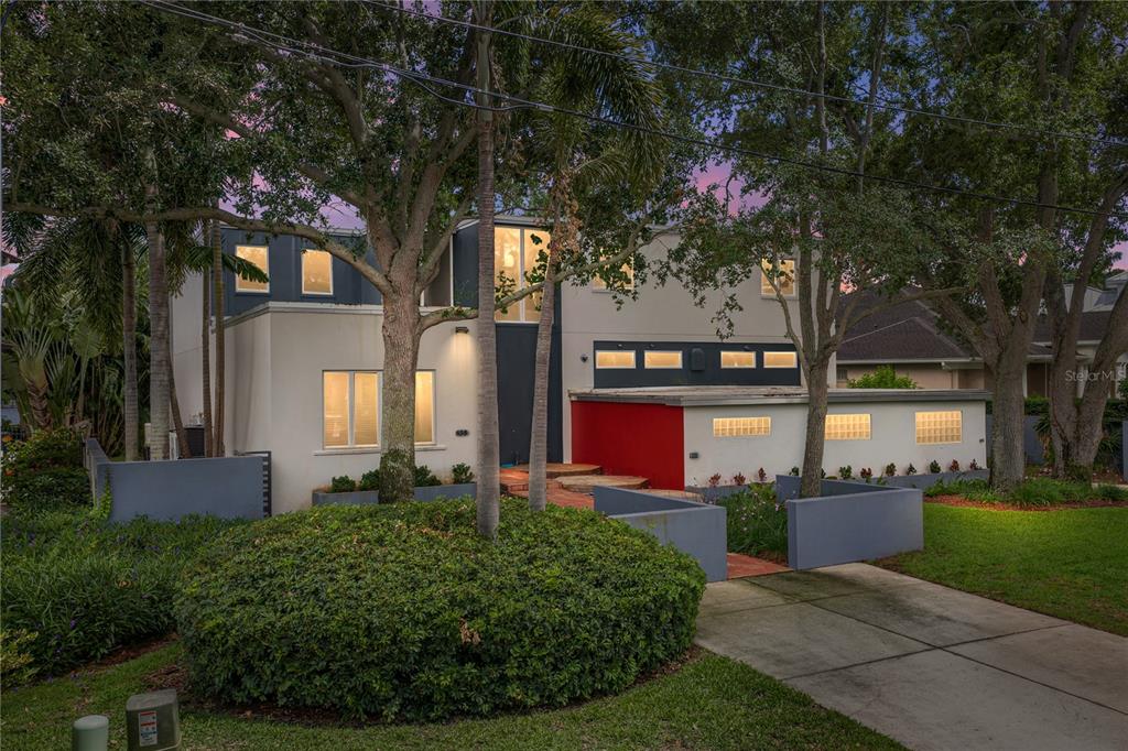 A two-story modern house with a red accent wall and a circular front garden — 838 MONTEREY BOULEVARD NE, ST PETERSBURG, FL