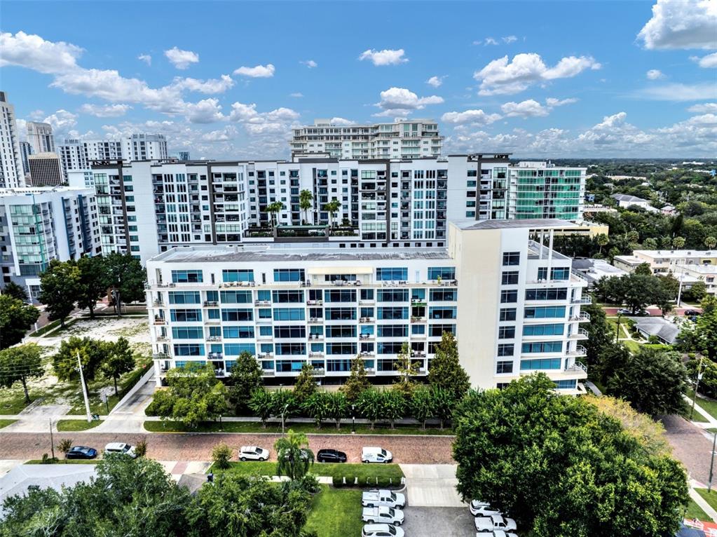 An aerial view of a multi-story apartment building with a brick street in the foreground — 525 E JACKSON STREET UNIT 402, ORLANDO, FL