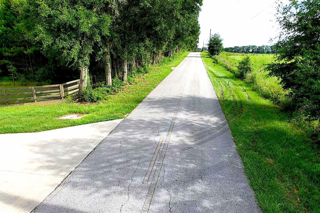 An aerial view of a large, grassy, undeveloped field with a dirt road nearby — 00 SW 210 AVENUE, DUNNELLON, FL