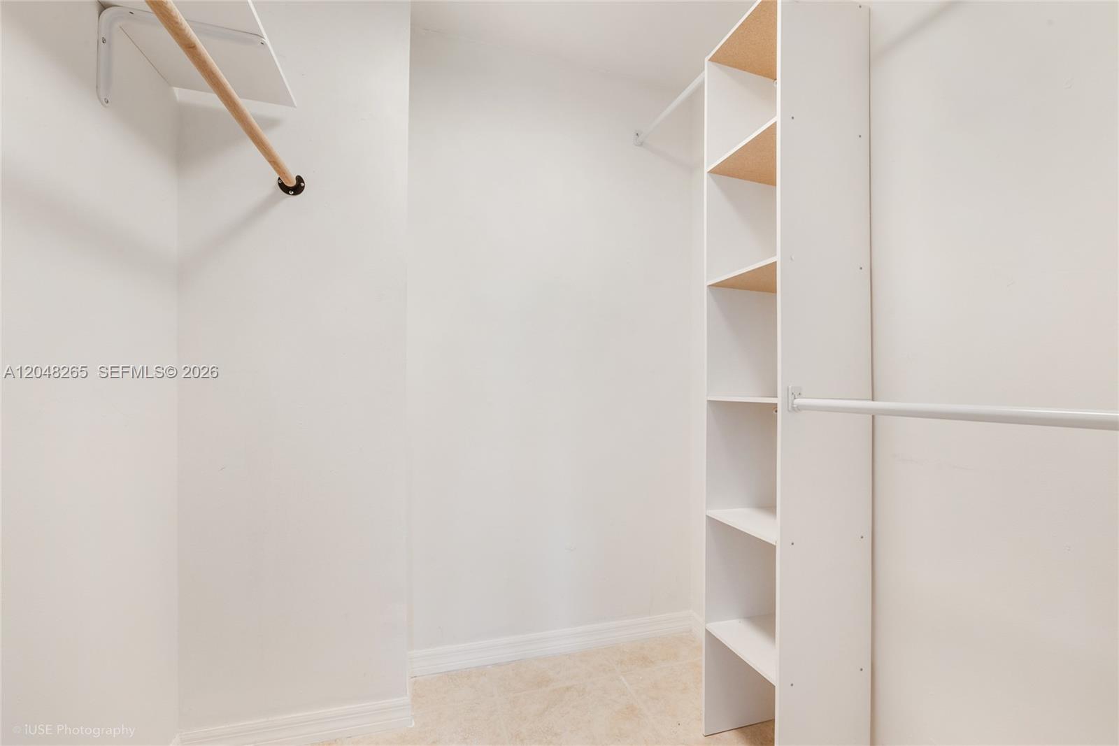 A walk-in closet features white walls, tile flooring, a shelving unit, and hanging rods — 9301 SW 92nd Ave # A304, Miami FL 33176, MIAMI, FL