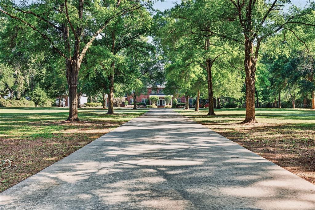 A large two-story red brick house features a circular driveway and a manicured lawn — 4940 E FORT KING STREET, OCALA, FL