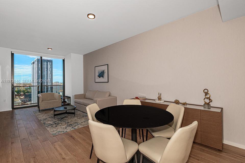 A dining area with a round table and a living space with floor-to-ceiling windows — 398 NE 5th St # 2418, Miami FL 33132, MIAMI, FL