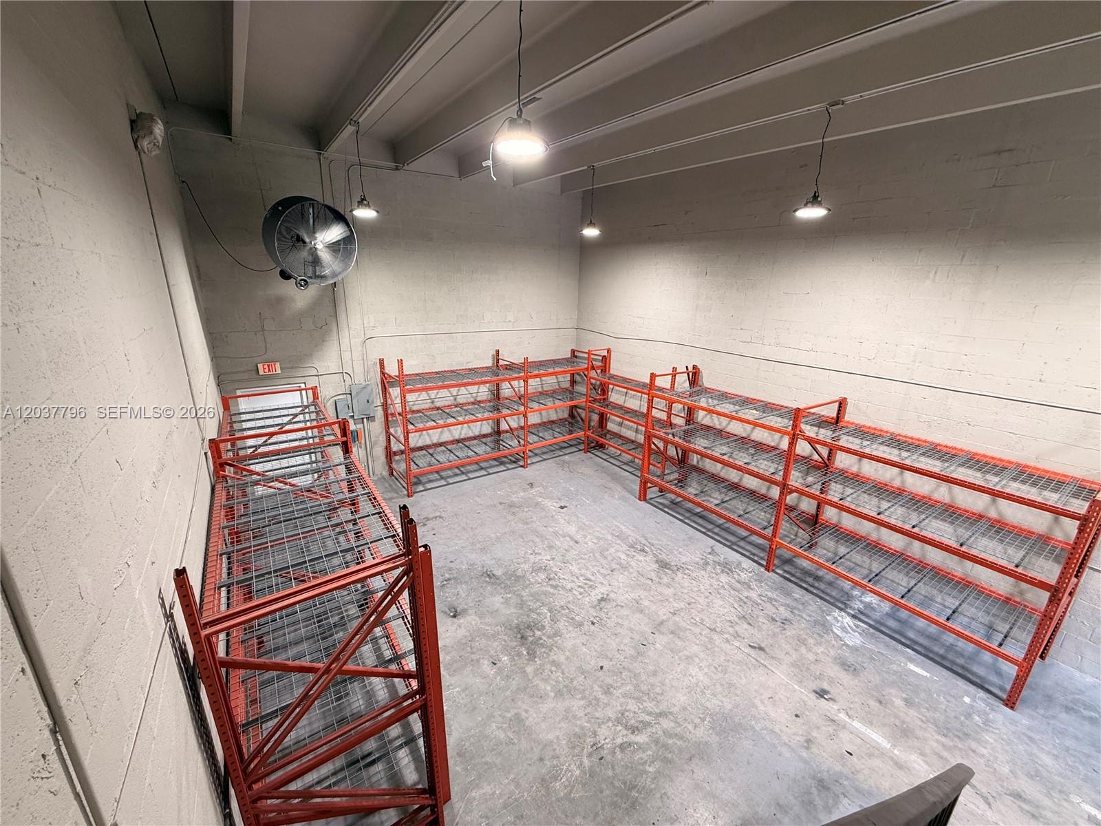 An industrial storage room features concrete walls, a concrete floor, and orange metal shelving units — 8060 W 23rd Ave # 8, Hialeah FL 33016, HIALEAH, FL
