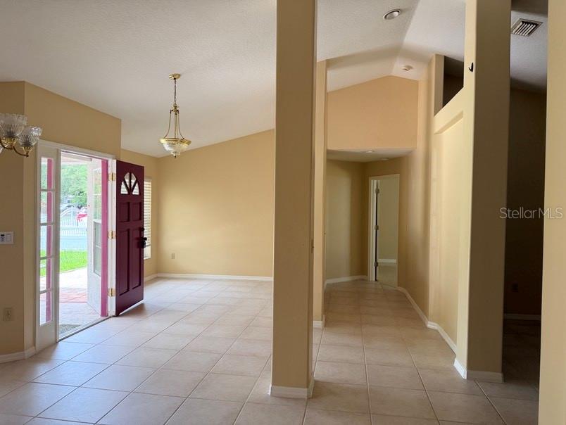 An entryway with tile flooring, a purple front door, and a vaulted ceiling — 12721 N OLA AVENUE, TAMPA, FL