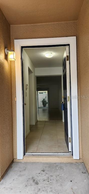 A view through an open front door into a tiled entryway and interior hallway — 2529 HARN BOULEVARD UNIT 4, CLEARWATER, FL