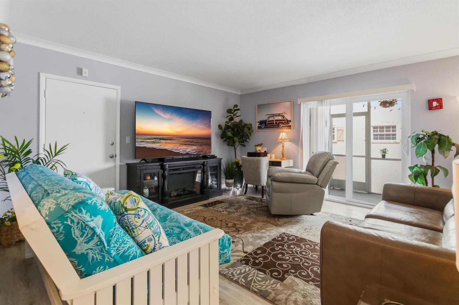 A living room features a television, a fireplace console, a recliner, and a sofa — 101 E Mcnab Road # 408, Pompano Beach FL 33060, POMPANO BEACH, FL