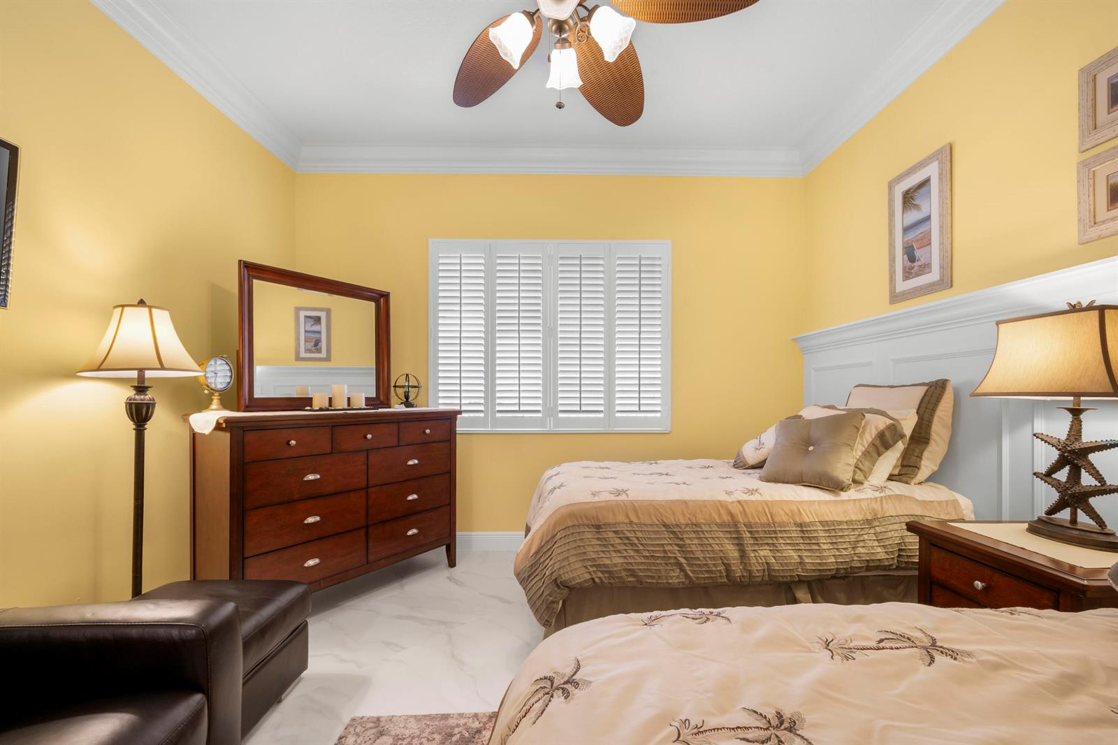 A bedroom features yellow walls, two beds, a wooden dresser, and a ceiling fan — 8 Harbour Isle Drive E, Fort Pierce FL 34949, FORT PIERCE, FL