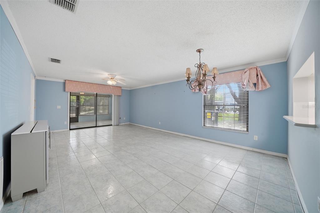 A dining room with light blue walls, tile flooring, a chandelier, and sliding glass doors — 2130 ELM STREET UNIT 401, DUNEDIN, FL