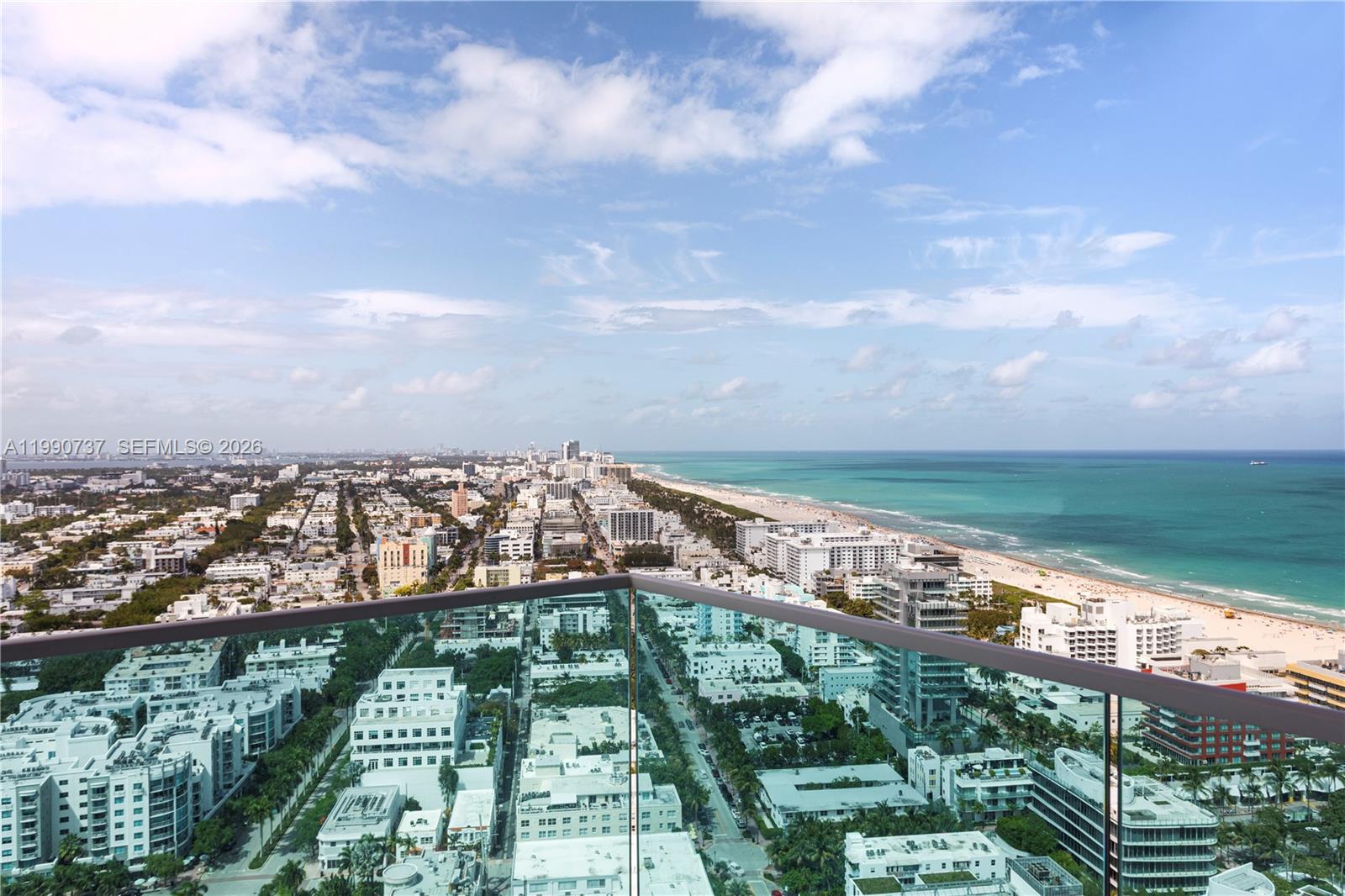 A high-angle view from a balcony overlooks a coastal city and the ocean — 300 S Pointe Dr # 3405, Miami Beach FL 33139, MIAMI BEACH, FL