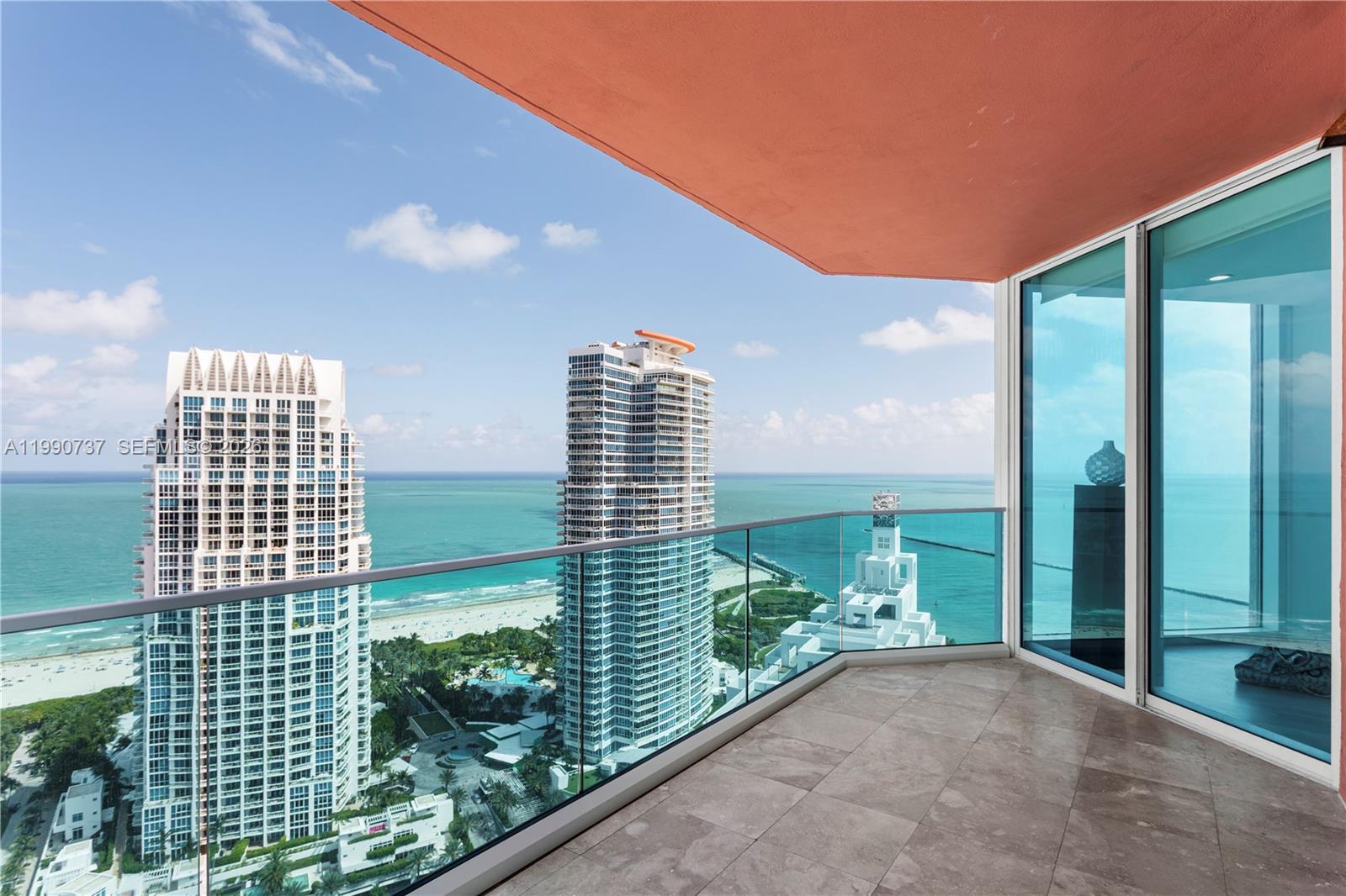 A balcony with tile flooring overlooks the ocean and high-rise buildings — 300 S Pointe Dr # 3405, Miami Beach FL 33139, MIAMI BEACH, FL