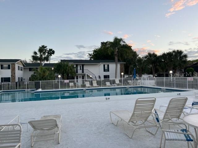 A swimming pool with lounge chairs sits in front of a two-story apartment building — 5400 34TH STREET W UNIT E8, BRADENTON, FL