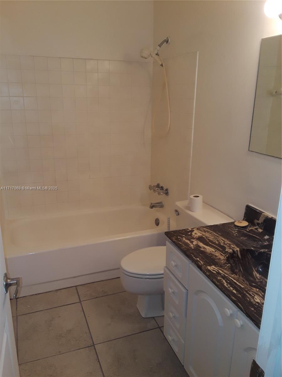 A bathroom features a white bathtub, a toilet, and a vanity with a dark countertop — 8267 SW 128th St # 105, Pinecrest FL 33156, PINECREST, FL