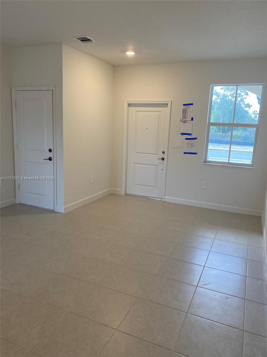 An empty room features white walls, tile flooring, two doors, and a window — 12623 NW 24th Ave # 12623, Miami FL 33167, MIAMI, FL