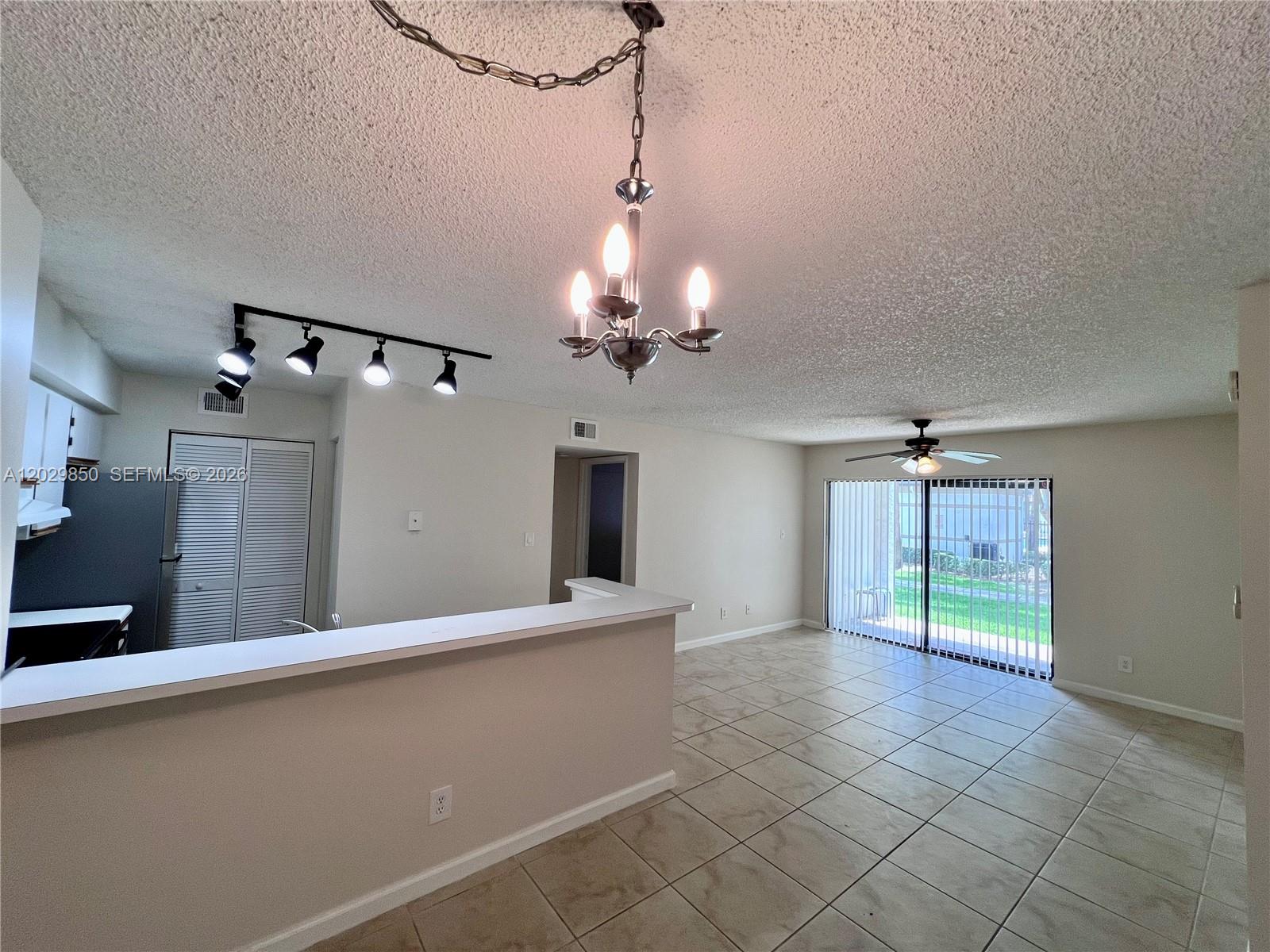 An open-concept living and dining area features tile flooring, a breakfast bar, and a chandelier — 640 S Park Rd # 4, Hollywood FL 33021, HOLLYWOOD, FL