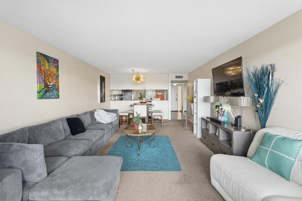 A living room features a grey sectional sofa, a white armchair, and a dining area — 8030 Hampton Boulevard # 404, North Lauderdale FL 33068, NORTH LAUDERDALE, FL