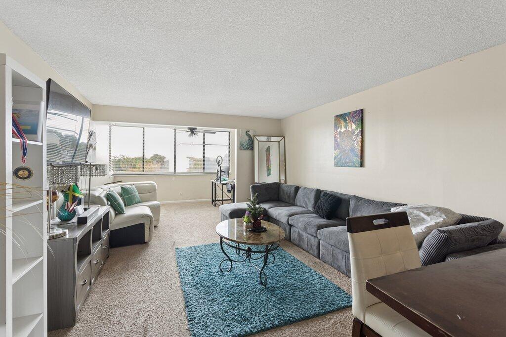 A living room features a large gray sectional, a white sofa, and a blue rug — 8030 Hampton Boulevard # 404, North Lauderdale FL 33068, NORTH LAUDERDALE, FL