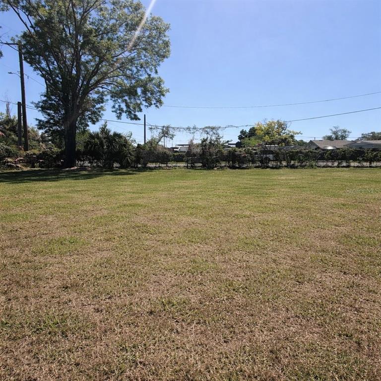 A large, flat, grassy vacant lot with a mature tree and a distant fence line — 2501 N 55TH STREET UNIT 2, TAMPA, FL