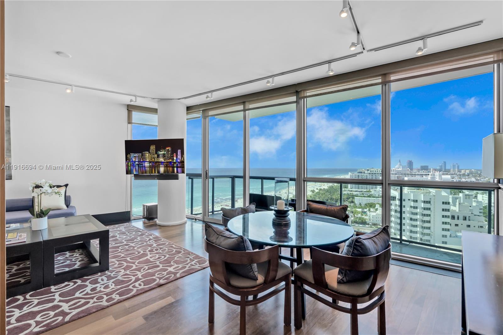 A living and dining area features floor-to-ceiling windows with ocean views and hardwood floors — 101 20th St # 2504, Miami Beach FL 33139, MIAMI BEACH, FL