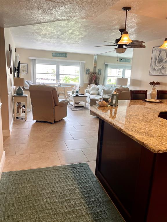 A view from a kitchen island looking into a living room with tile flooring — 4650 COVE CIRCLE UNIT 402, ST PETERSBURG, FL