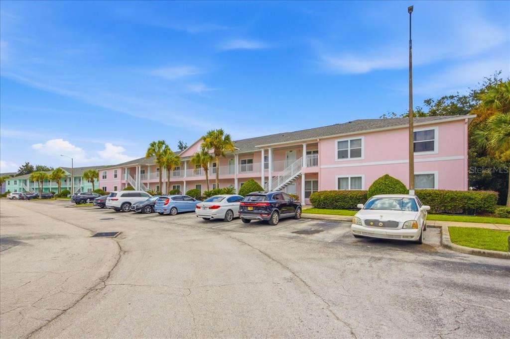 A pink multi-story apartment building with a parking lot in front — 3157 SUN LAKE COURT UNIT B, KISSIMMEE, FL