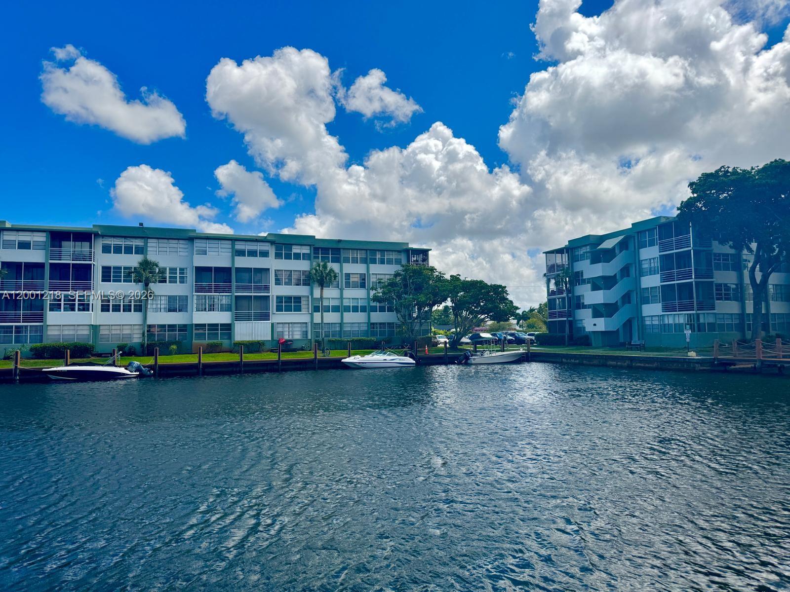 Two multi-story apartment buildings sit along a canal with several small boats docked outside — 2741 Taft St # 404, Hollywood FL 33020, HOLLYWOOD, FL