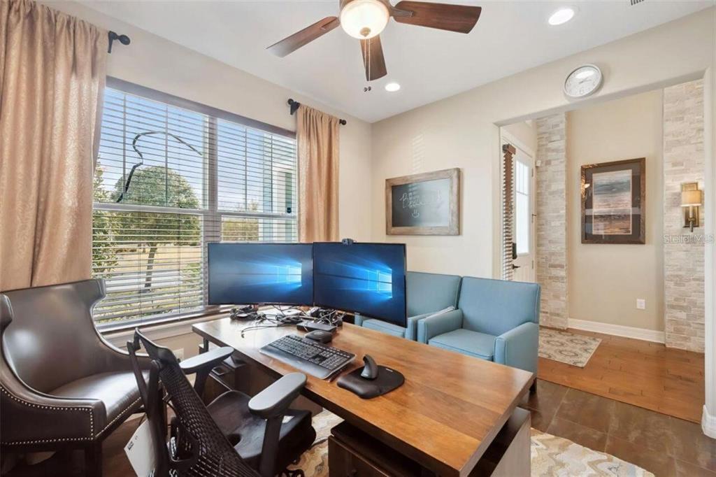 A home office features a wooden desk with dual monitors, a ceiling fan, and a chair — 2683 AMATI DRIVE, KISSIMMEE, FL