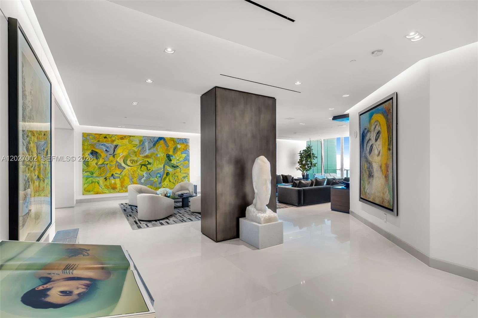 A modern living area features white floors, a central dark pillar, and several large paintings — 350 Ocean Dr, Key Biscayne FL 33149, KEY BISCAYNE, FL