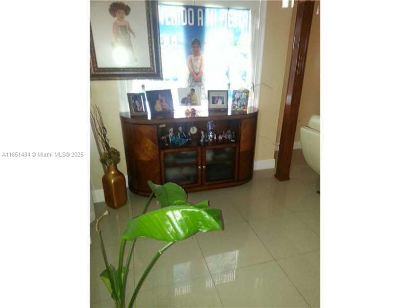 A wooden console table sits against a window in a room with tiled flooring — 321 NW 13th Ave, Miami FL 33125, MIAMI, FL