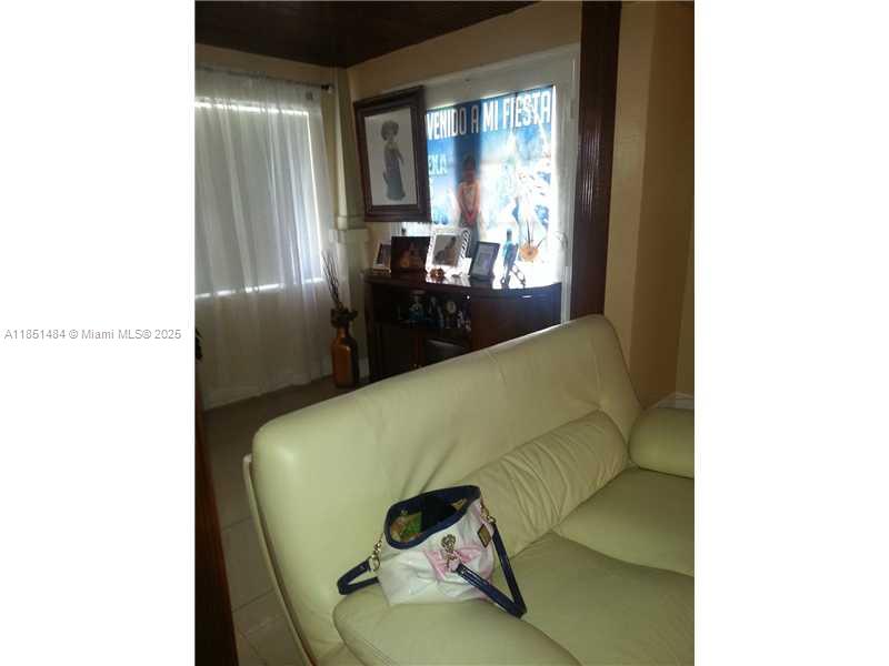 A light-colored sofa sits in a living room with a dark wood ceiling and console — 321 NW 13th Ave, Miami FL 33125, MIAMI, FL