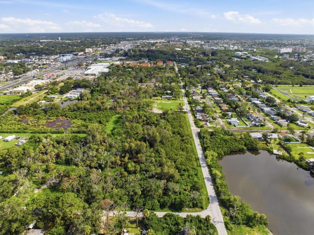 An aerial view shows a wooded lot next to a road and a small lake — 6814 OELSNER STREET, NEW PORT RICHEY, FL