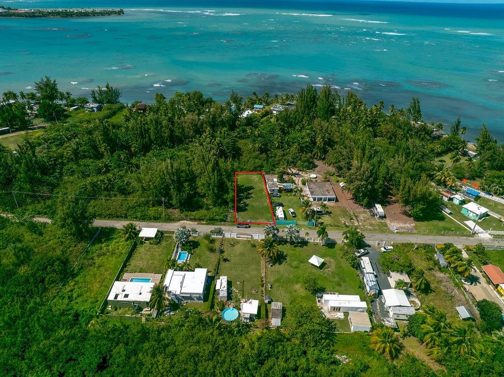 An aerial view shows a rectangular vacant lot outlined in red near a tropical coastline — PR 968 Km. 2.0, LAS PICUA PR 968 KM. 2.0, LOT 18A, PUNTA ARENA, LAS PICUAS UNIT 18A, RIO GRANDE, PR