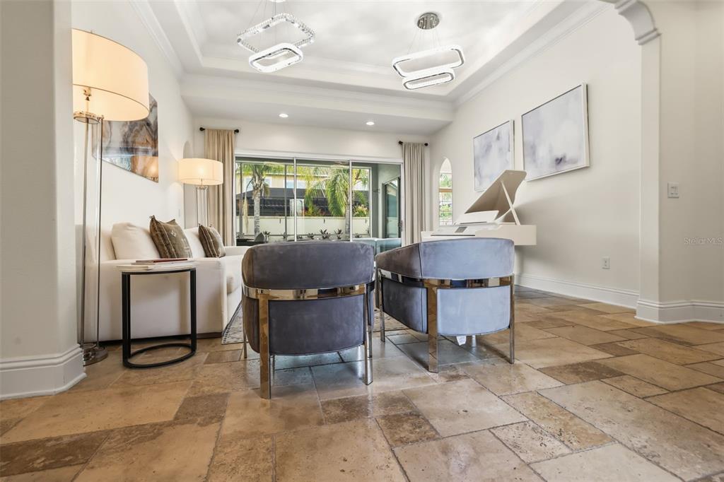 A living room features a white piano, two gray armchairs, a sofa, and tile flooring — 12417 MONTALCINO CIRCLE, WINDERMERE, FL