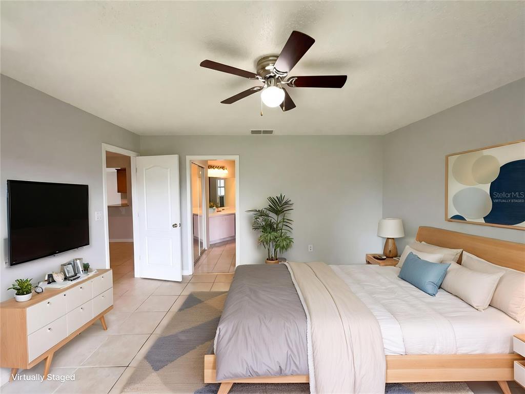 A bedroom features a bed, a television on a dresser, and a ceiling fan — 724 HARLAND COURT, KISSIMMEE, FL