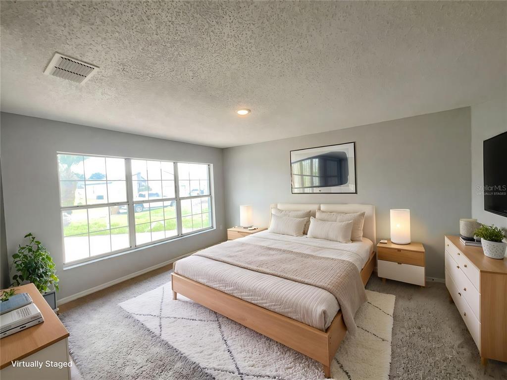 A bedroom features a light wood bed frame, a white rug, and large windows — 724 HARLAND COURT, KISSIMMEE, FL