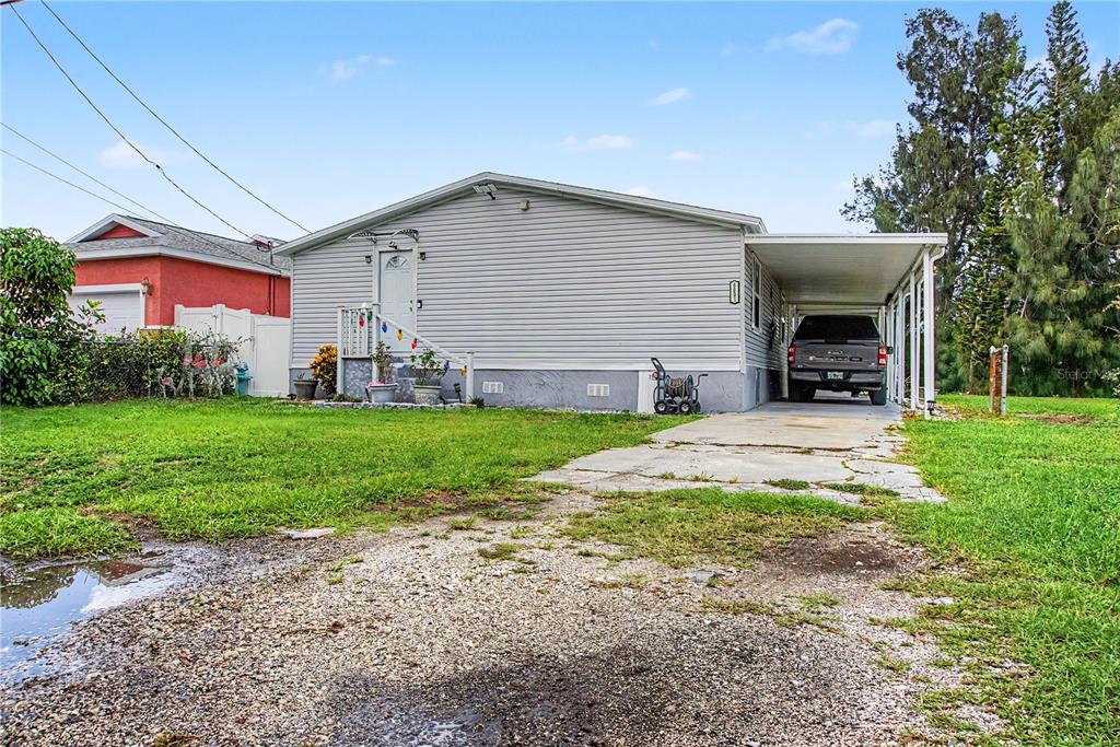 A single-story house with light gray siding, a front porch, and a side carport — 6601 51ST WAY N, PINELLAS PARK, FL